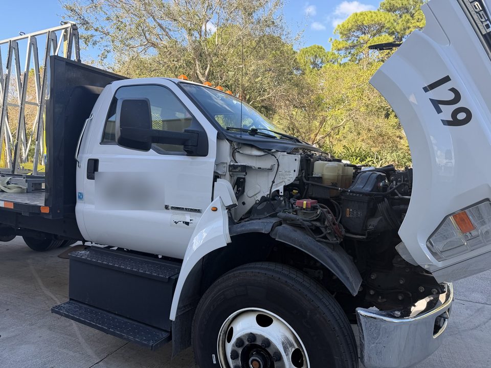 Ford F-650 with the hood tilted forward during on-site starter replacement